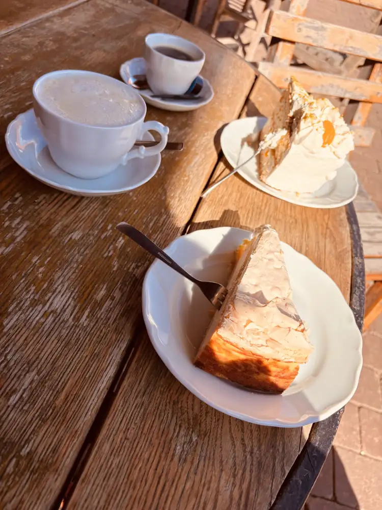 Kaffee und zwei Stück hausgemachte Torte auf einem Holztisch im Hof-Café am Pfarrhaus in Gieboldehausen