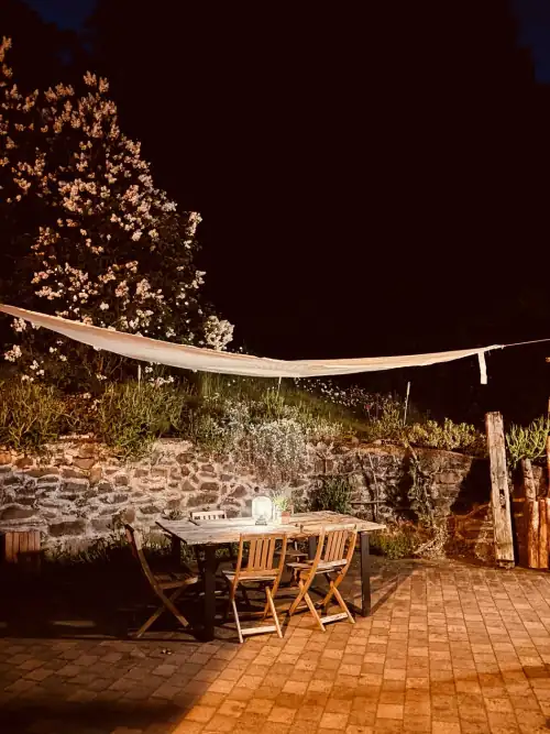 Innenhof am Abend – gedeckter Tisch unter dem Sonnensegel